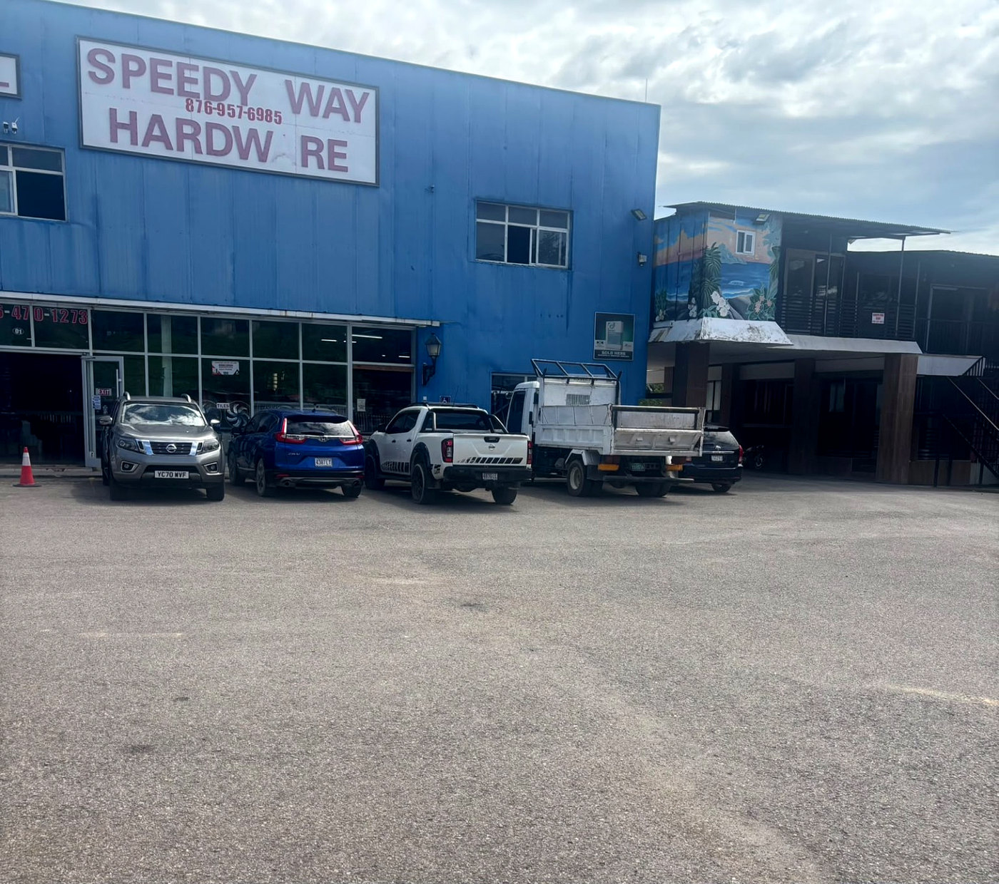 Genuine photograph of the Speedy Way Hardware blue storefront in Orange Bay, Jamaica, with its existing signage unchanged